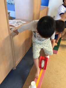 子ども達が壁に手のつく位置に平均台がセットされています。