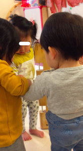 黄色いセーターの子が、手を繋いで入ってきた二人の間に入ろうとします。